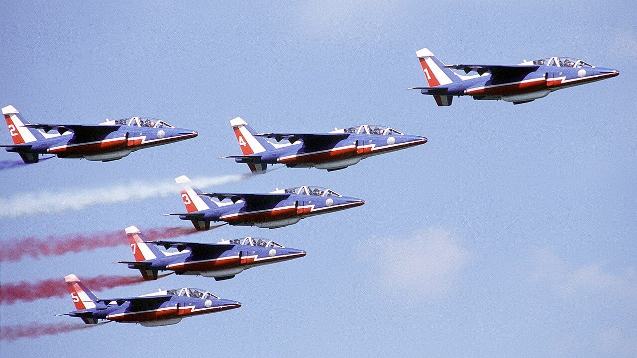 Six Patrouille de France Alpha Jets in formation trailing red, white and blue smoke