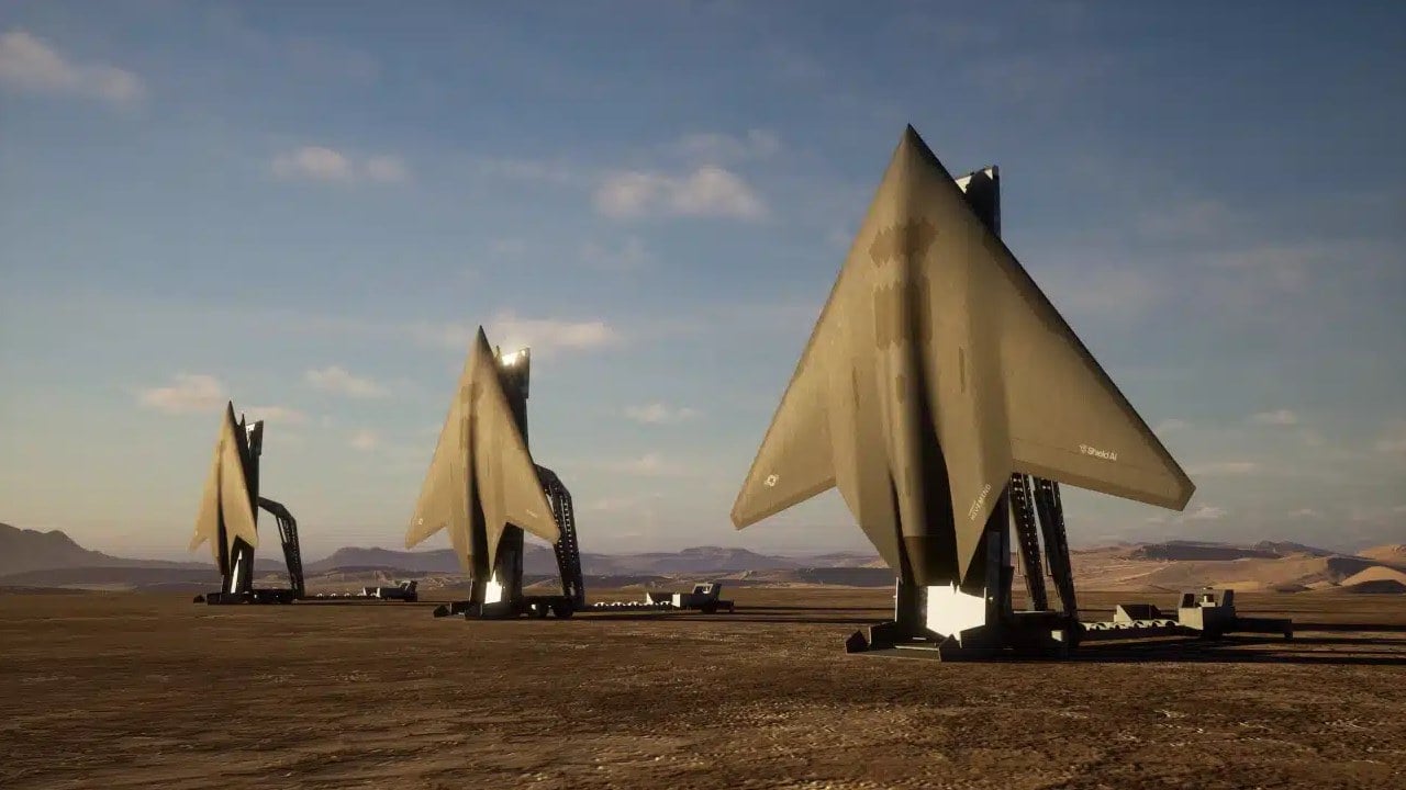 Shield AI rendering of three X-BAT AI-piloted VTOL jets standing upright on their launch and recovery vehicles at a desert land base