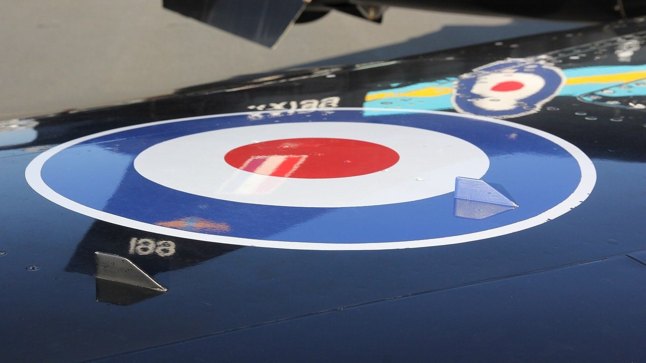Two delta-shaped vortex generators on the glossy dark upper wing of an RAF BAE Hawk T1 beside its roundel