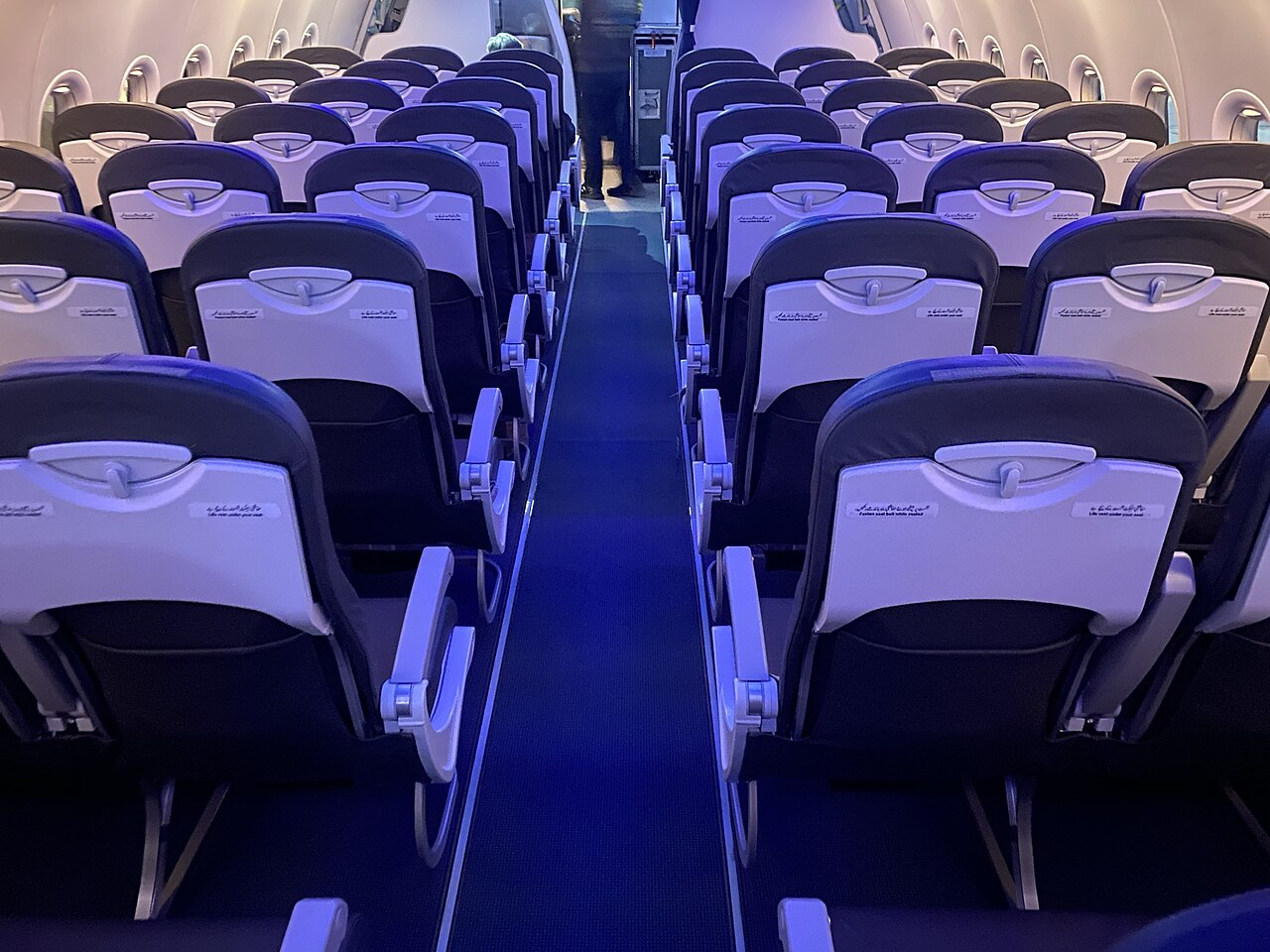 Airbus A320 economy cabin aisle seen from the rear towards the front