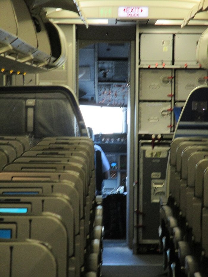 View down the aisle of a JetBlue Airbus A320 through the open cockpit door during boarding
