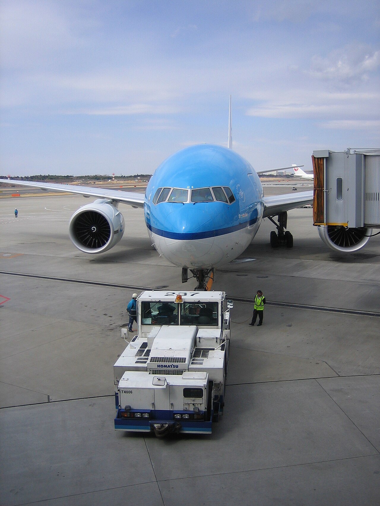 KLM Boeing 777 being pushed back from the gate at Narita by a conventional towbar tug