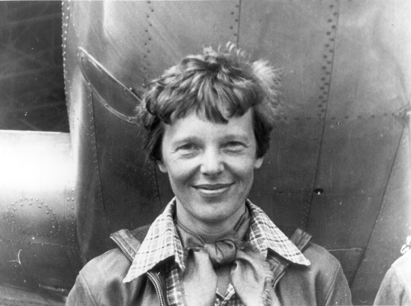 Amelia Earhart standing under the nose of her Lockheed Model 10-E Electra