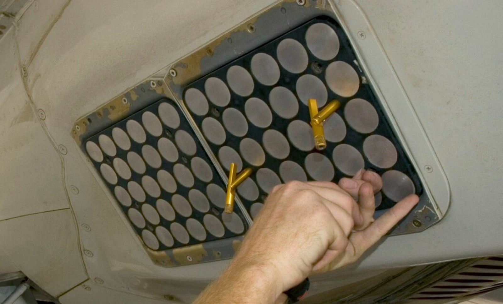 Close-up of an AN/ALE-47 countermeasures dispenser showing its grid of cartridge tubes loaded in an aircraft underside