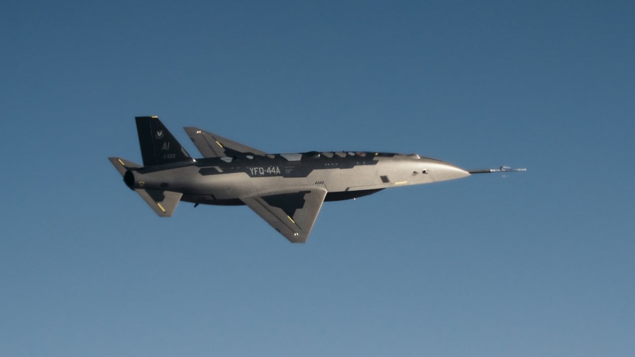 Anduril YFQ-44A collaborative combat aircraft in banking flight against a blue sky
