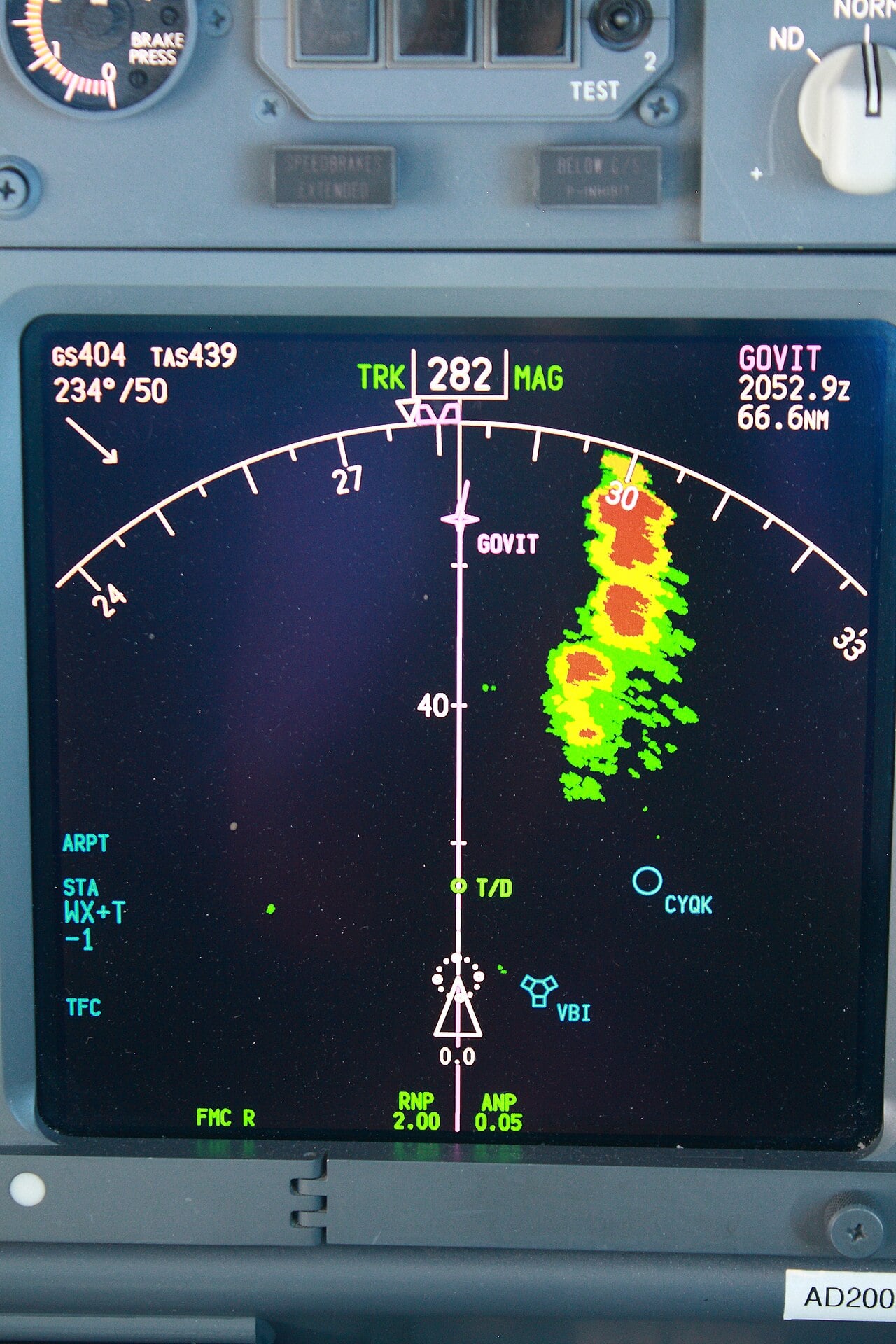 Boeing 737NG navigation display with green, yellow and red weather radar returns from a line of thunderstorms to the right of track