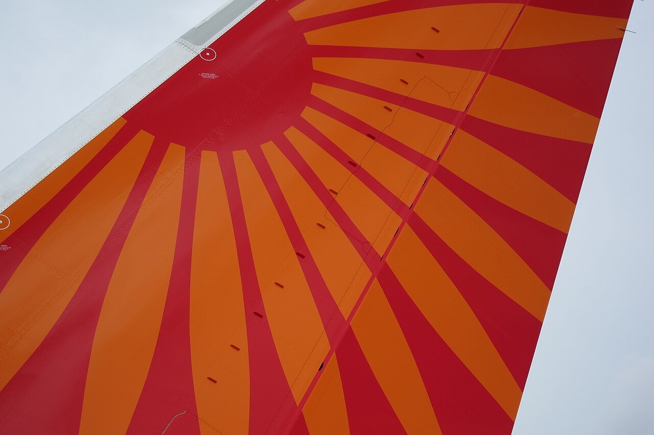 A diagonal row of small vortex generators across the red and orange fin of an Air India Boeing 787