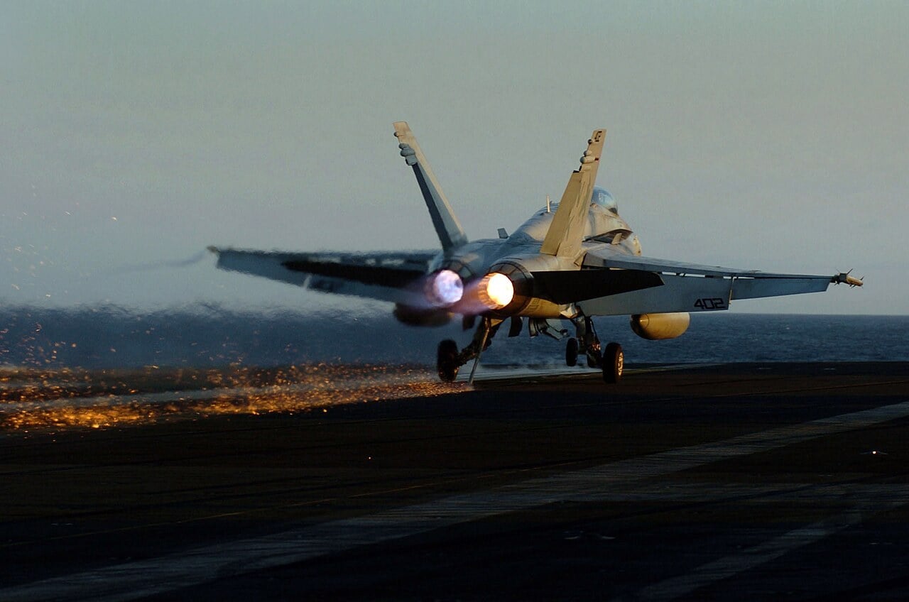 Sparks fly from the tailhook of a US Navy F/A-18C Hornet as full power is applied after a bolter on USS John C. Stennis