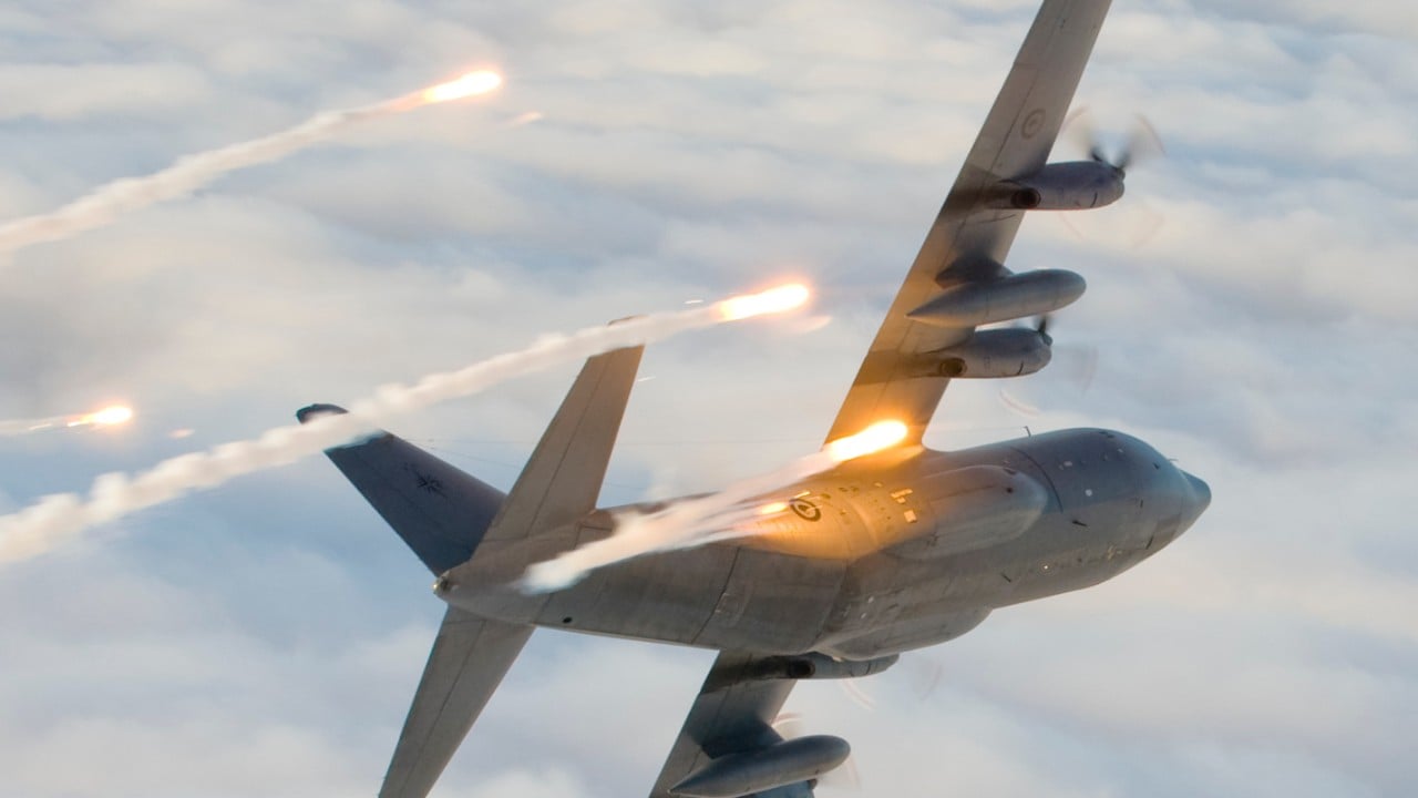 RNZAF C-130 Hercules releasing self-protection flares above the clouds