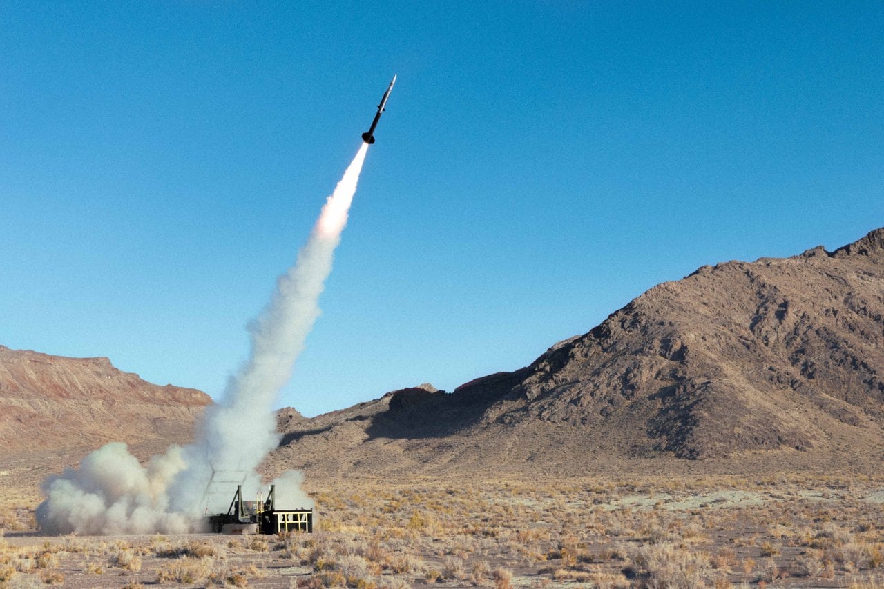 A Castelion Blackbeard test vehicle launching from a ground launcher in the desert, trailing white smoke