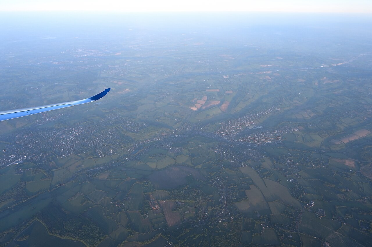 Aerial view of the town of Chesham and the surrounding Chiltern countryside from an airliner window, with a winglet visible