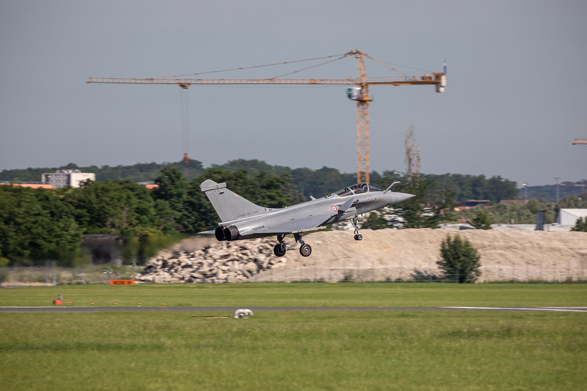 A French Air Force Dassault Rafale in flight with its landing gear extended at Le Bourget