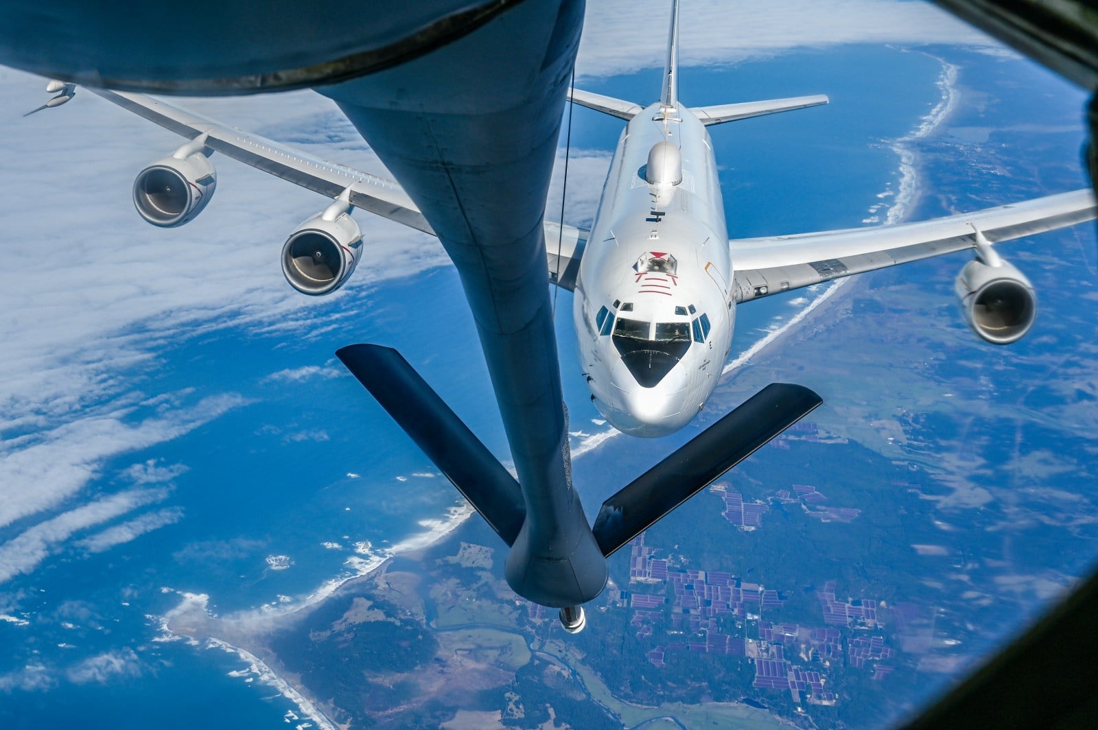 A US Navy E-6B Mercury approaches the boom of a US Air Force tanker over the Oregon coast