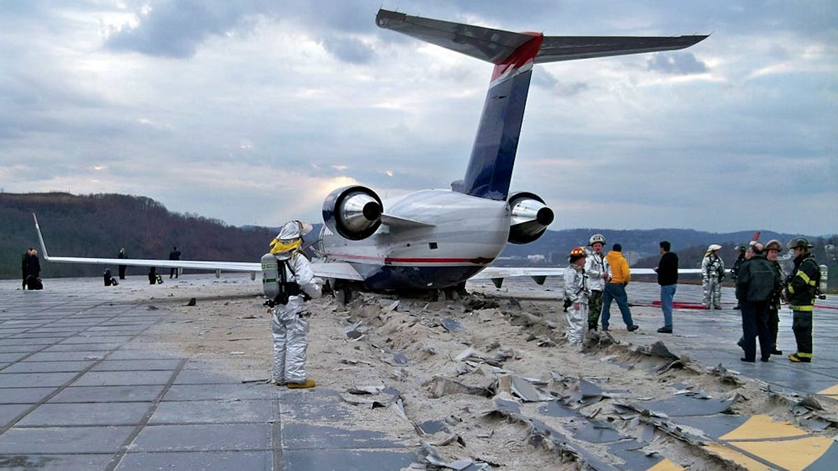 Regional jet stopped nose-down in a collapsed EMAS arrestor bed with emergency crews around it