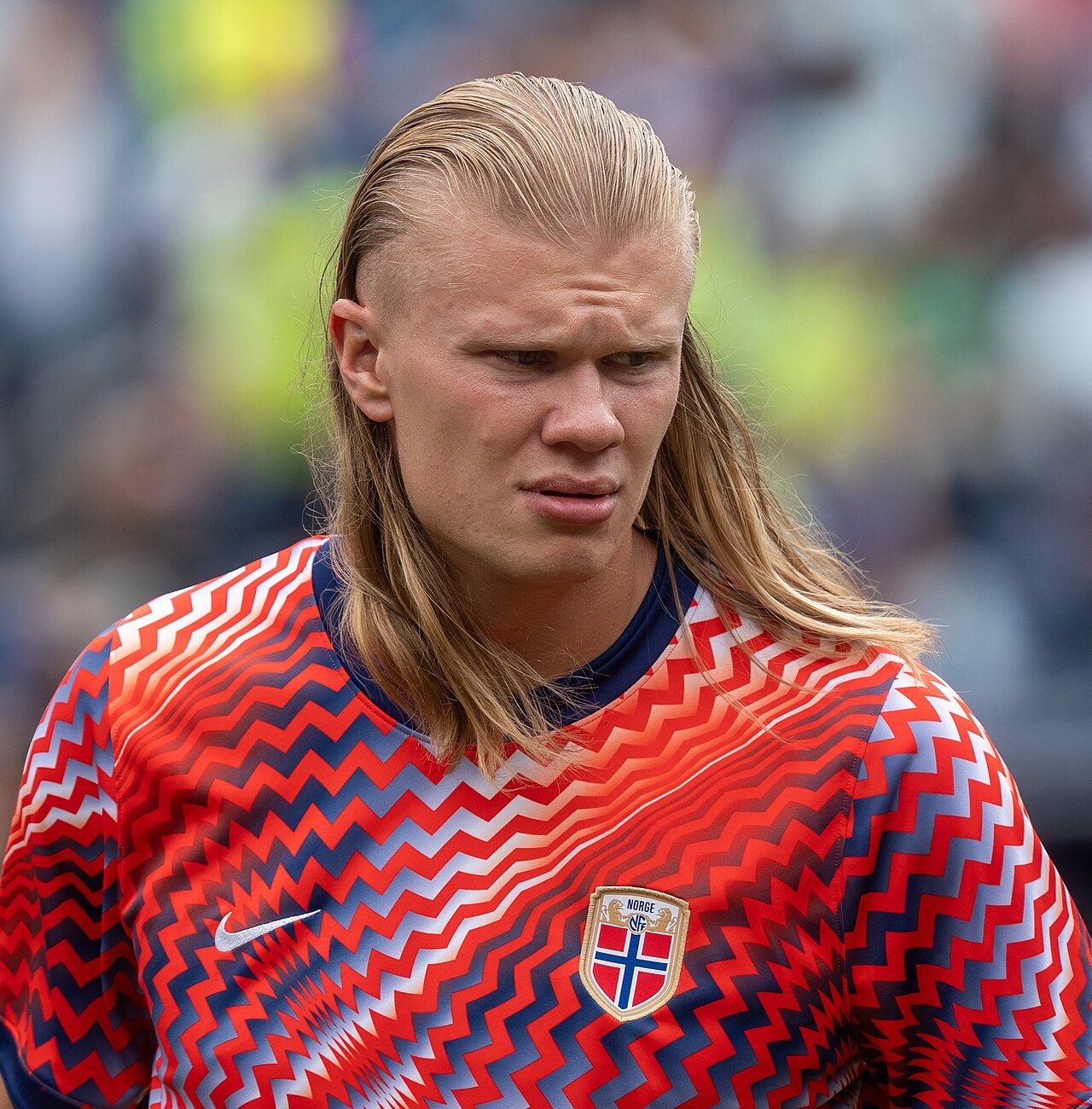Erling Haaland with long blond hair, wearing a red Norway warm-up shirt at the 2026 FIFA World Cup