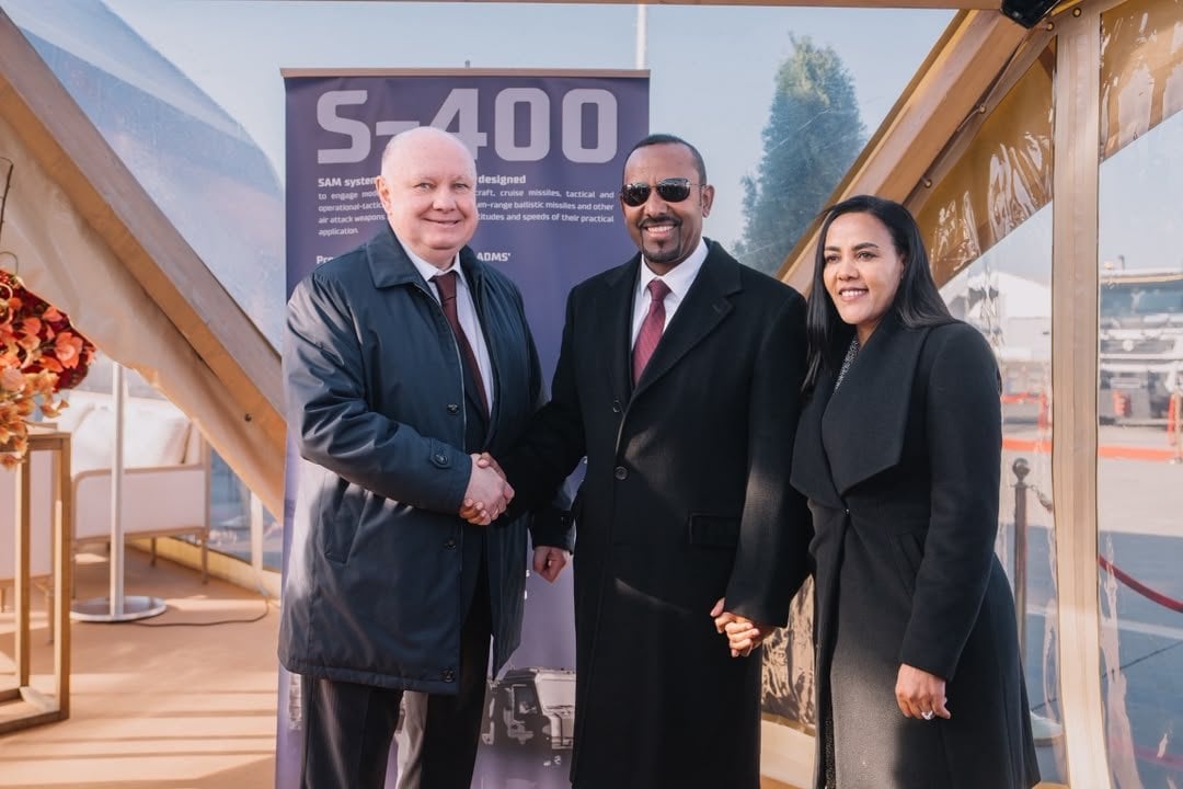 Abiy Ahmed shakes hands with a Russian official in front of an S-400 display in Moscow