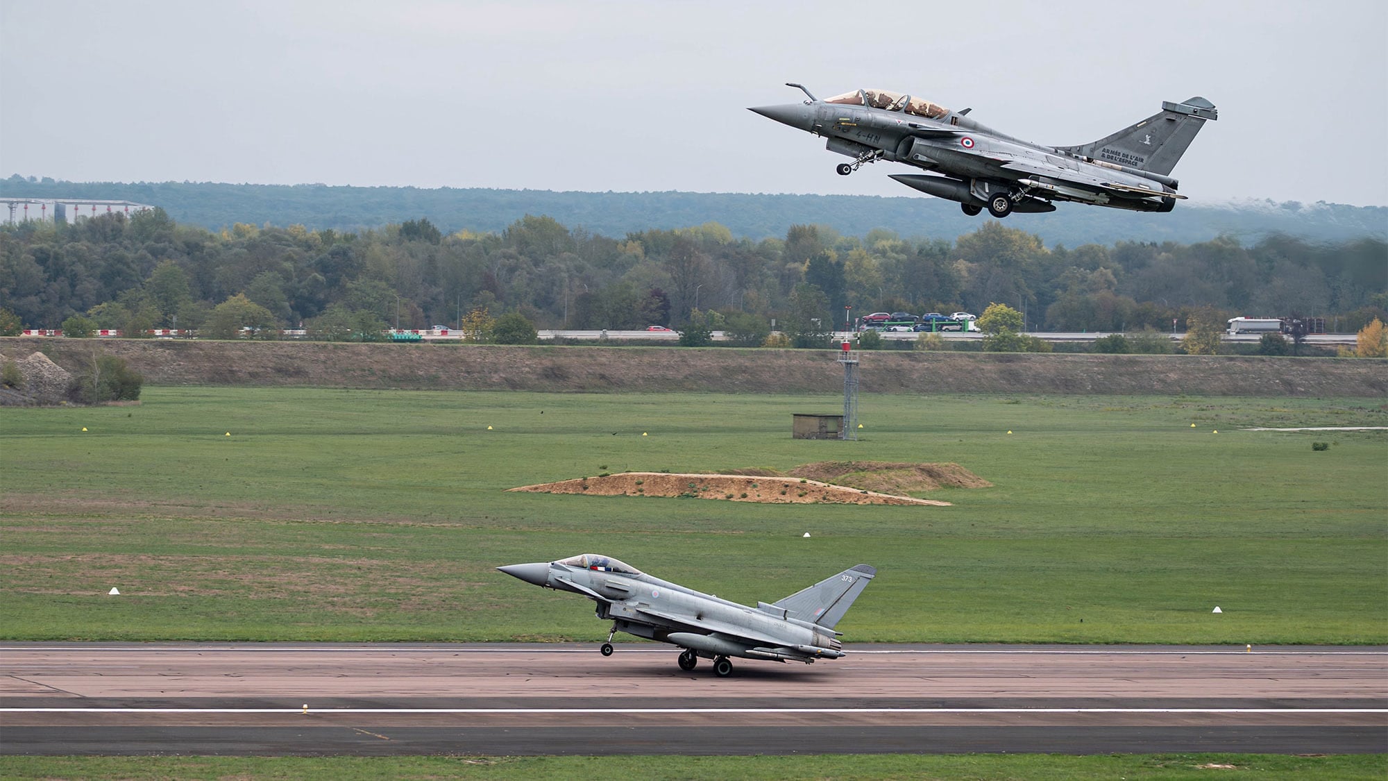 Exercise RUMMY: RAF Typhoon and Rafale B at Saint-Dizier A French Rafale B takes off above an RAF Typhoon on the runway at Saint-Dizier during Exercise RUMMY