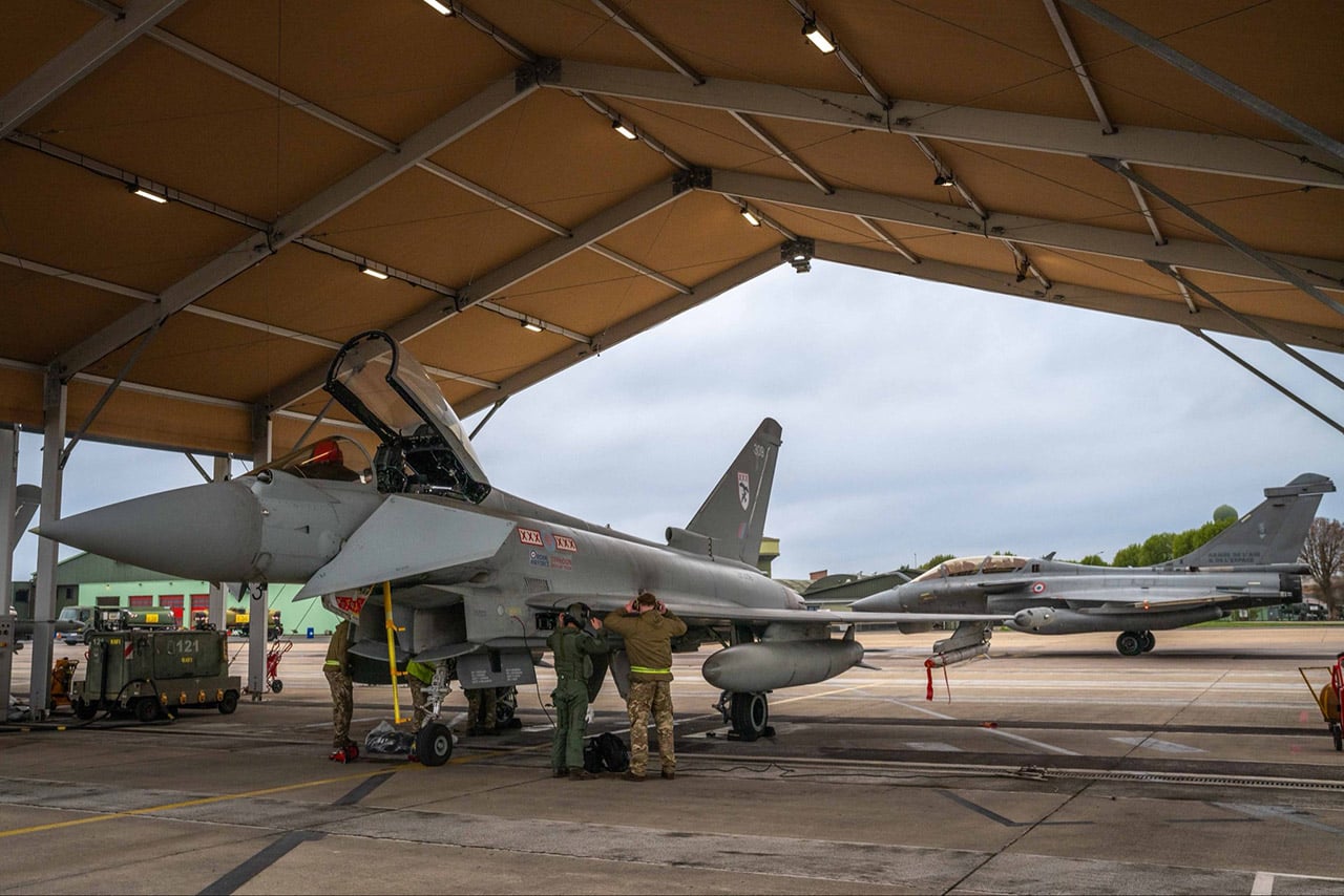 An RAF Typhoon FGR4 being prepared under a shelter at Saint-Dizier, with a Rafale B behind it