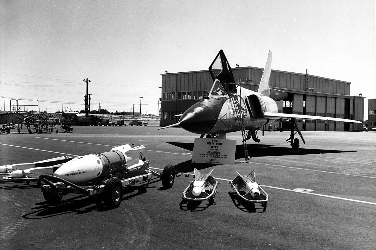 Convair F-106A Delta Dart on a ramp with four AIM-4 Falcon missiles and an AIR-2 Genie nuclear rocket laid out in front of it