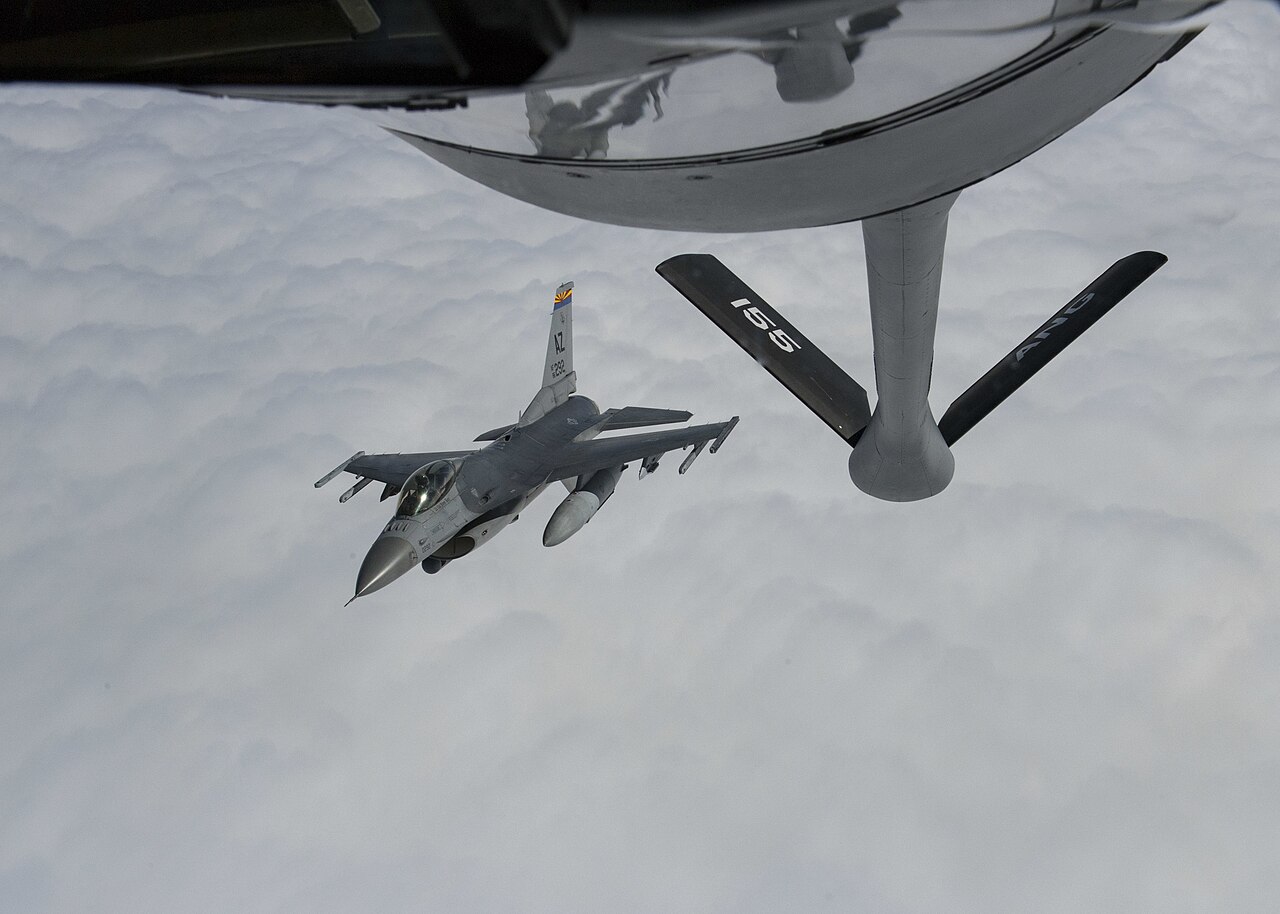 F-16C Fighting Falcon closing on a KC-135 Stratotanker boom above cloud