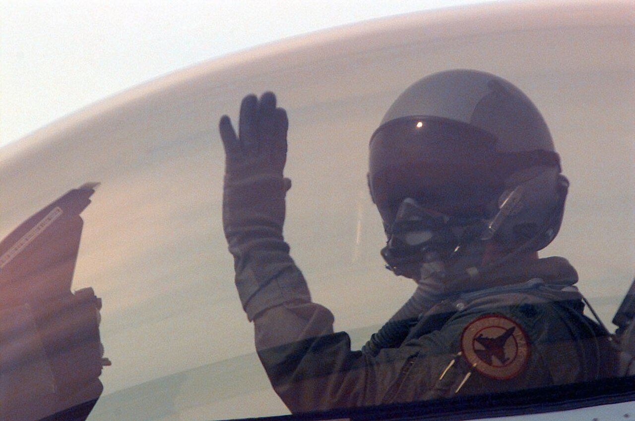 South Dakota Air National Guard F-16C pilot waving from under a gold-tinted canopy at Ahmed Al Jaber Air Base, Kuwait, in 1998