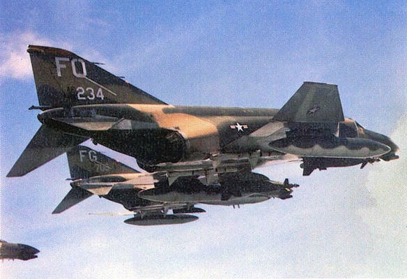 Two USAF F-4D Phantom IIs of the 8th Tactical Fighter Wing in flight, the nearer one carrying laser-guided bombs