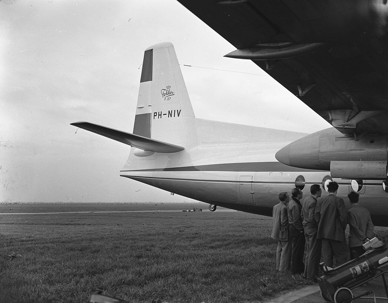 Tail of the Fokker F27 prototype PH-NIV with Fokker F.27 logo, men inspecting the Rolls-Royce Dart nacelle in November 1955
