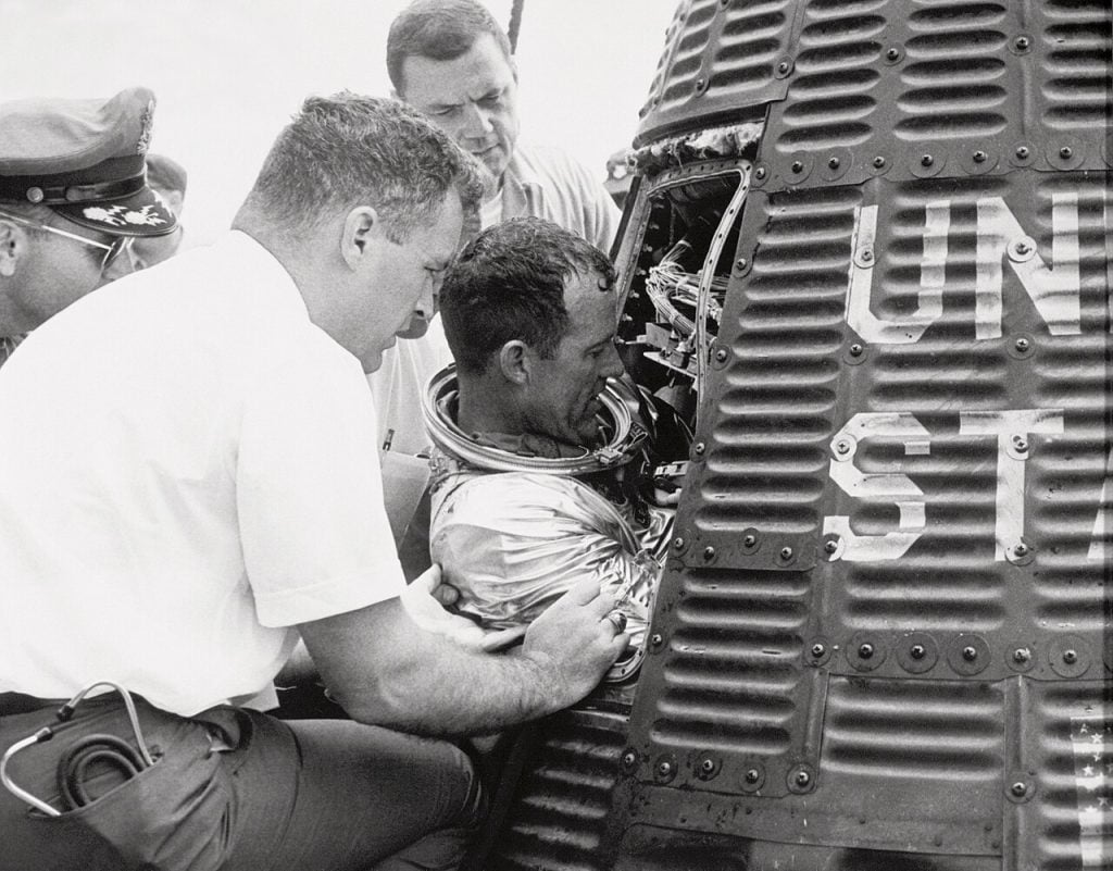 Gordon Cooper climbing out of Faith 7 on the deck of USS Kearsarge