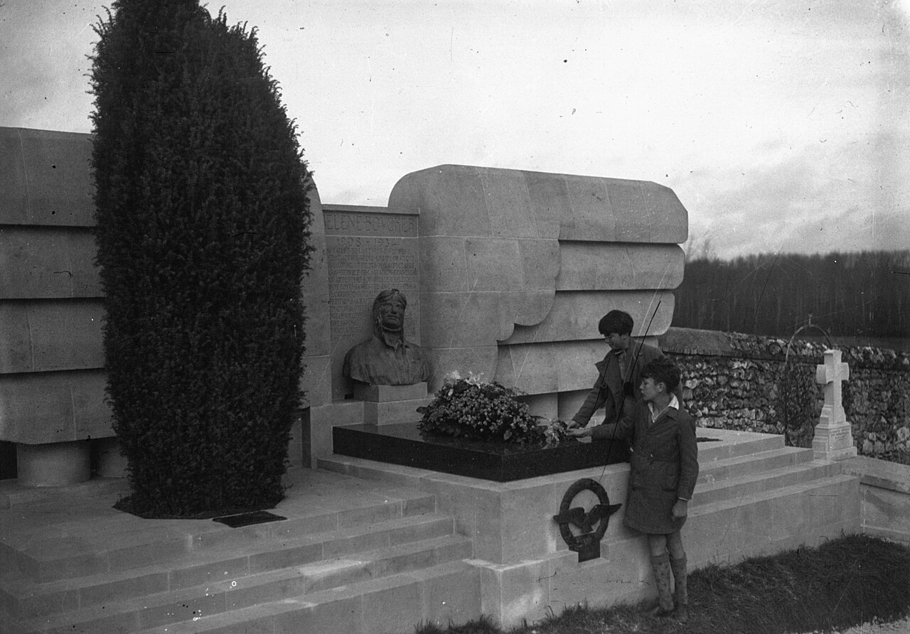 Hélène Boucher's tomb at Yermenonville with a bronze bust, stone wings and two boys laying flowers