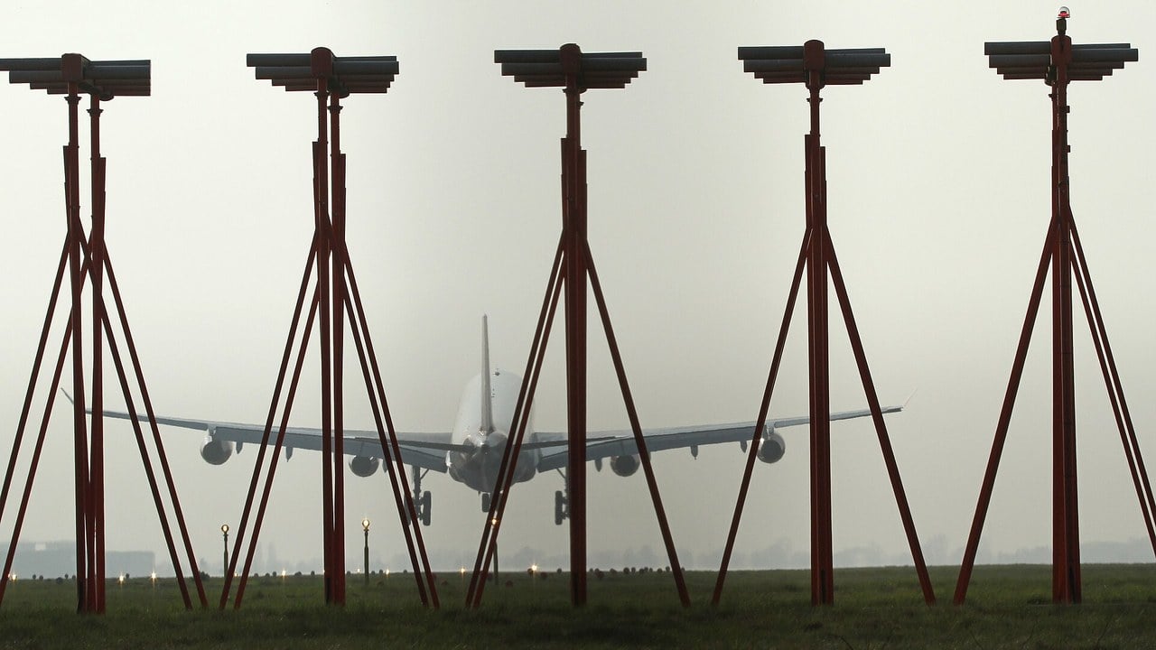 Airliner landing behind ILS localizer antennas A four-engined airliner on final approach in haze, seen through the masts of an ILS localizer antenna array