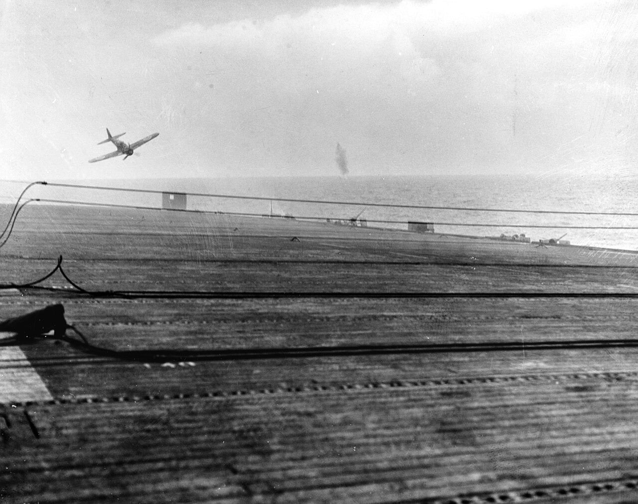 A Japanese Zero kamikaze diving towards the escort carrier USS White Plains, seen from her flight deck, 25 October 1944