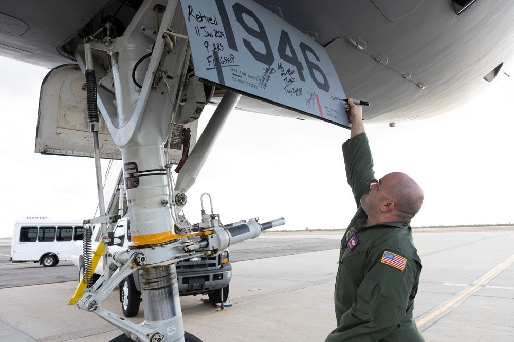 A boom operator signs the nose gear door of KC-10 Extender 79-1946 after delivering it to the boneyard at Davis-Monthan