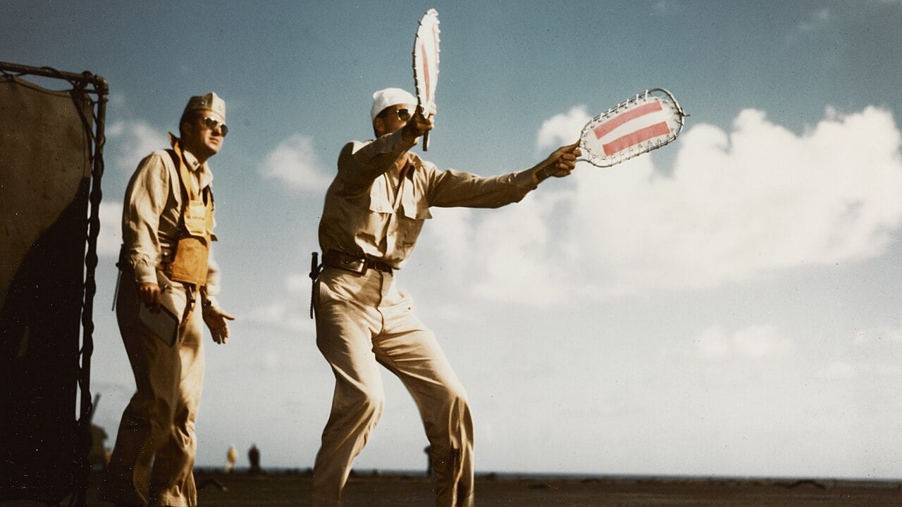 Landing signal officer with paddles aboard USS Lexington, 1943