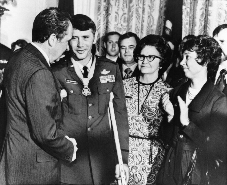 Leo Thorsness on a crutch, wearing the Medal of Honor, shaking hands with President Richard Nixon
