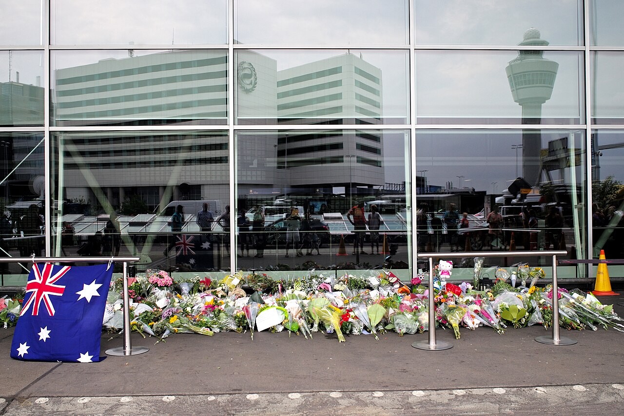 Flowers and an Australian flag laid along the terminal windows at Amsterdam Schiphol Airport in July 2014
