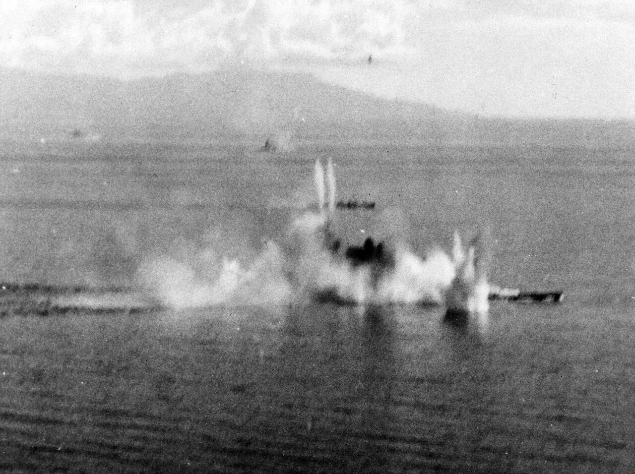 Bomb splashes and smoke around the Japanese battleship Musashi under attack by US Navy aircraft in the Sibuyan Sea