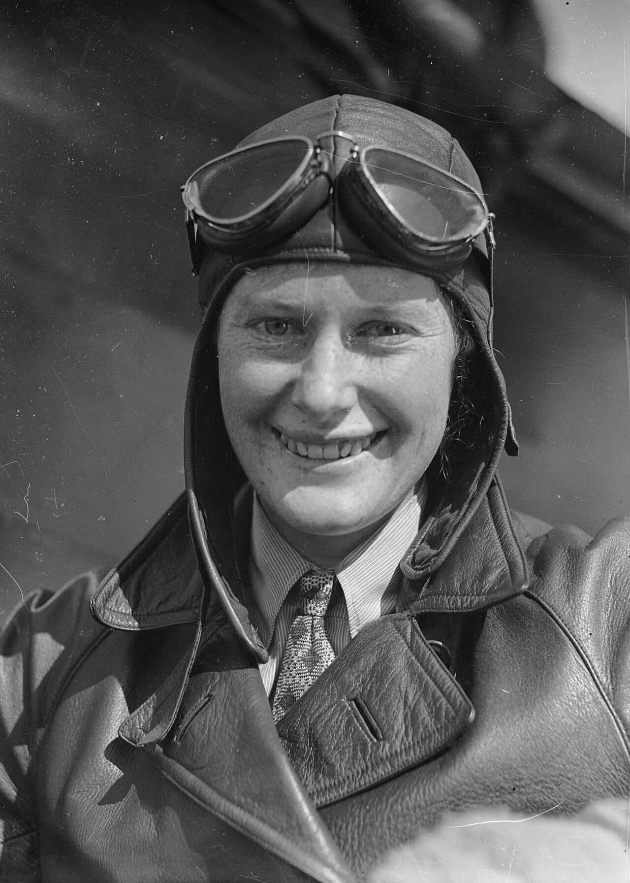 Black and white portrait of Australian aviator Nancy Bird in a leather flying helmet, goggles and jacket, 1933