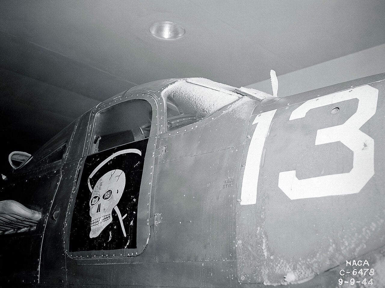 A frost-covered Bell P-39 Airacobra fuselage with a skull emblem inside the NACA Icing Research Tunnel in 1944