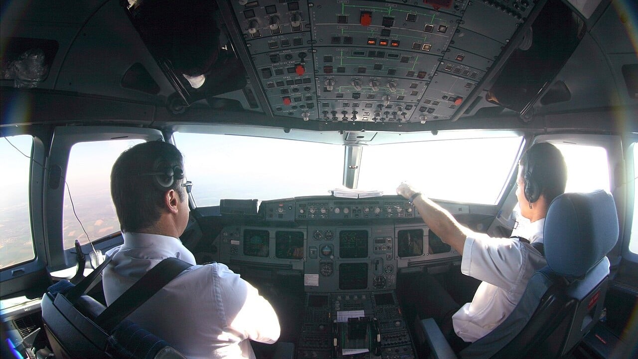 Two airline pilots at work in the cockpit of an Air France Airbus A320 family aircraft during descent towards Paris-Orly