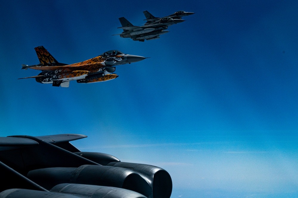 Portuguese Air Force F-16s flying in formation beside a US B-52H bomber