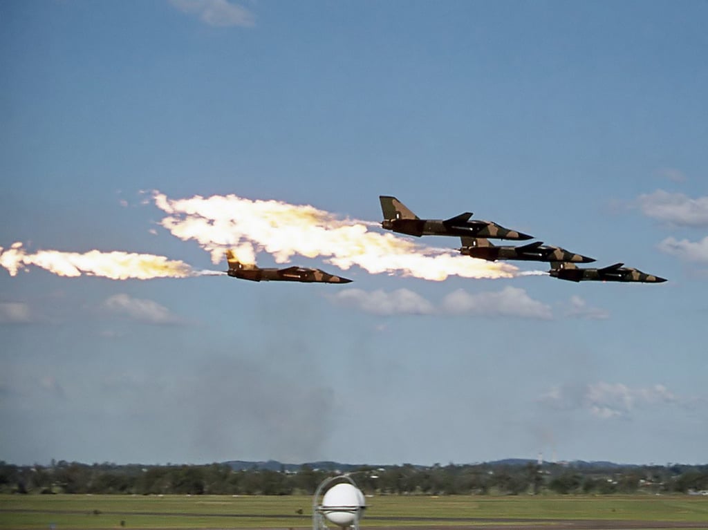 Four RAAF F-111C aircraft performing a low-pass dump and burn