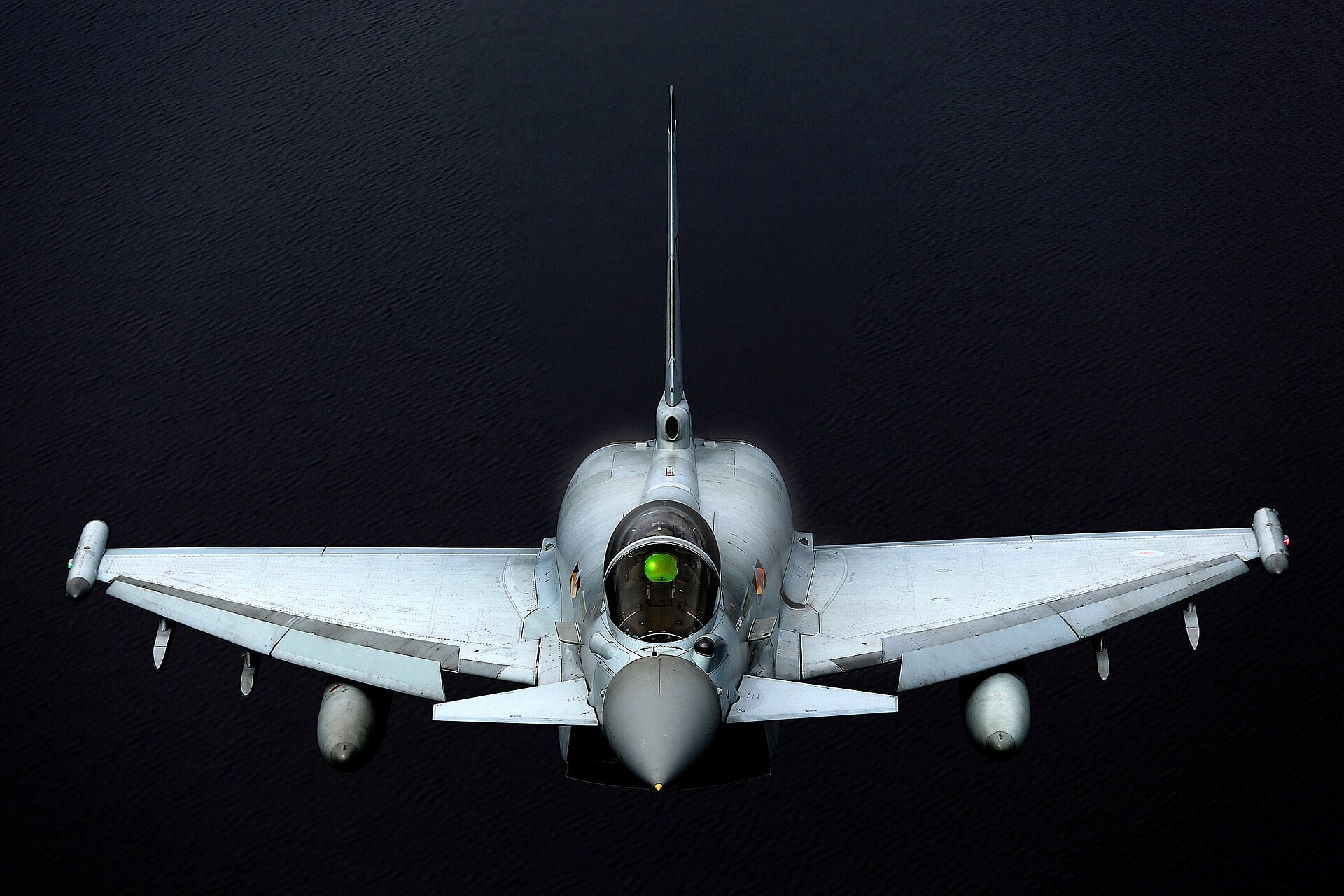 An RAF Eurofighter Typhoon seen head-on in flight over dark water