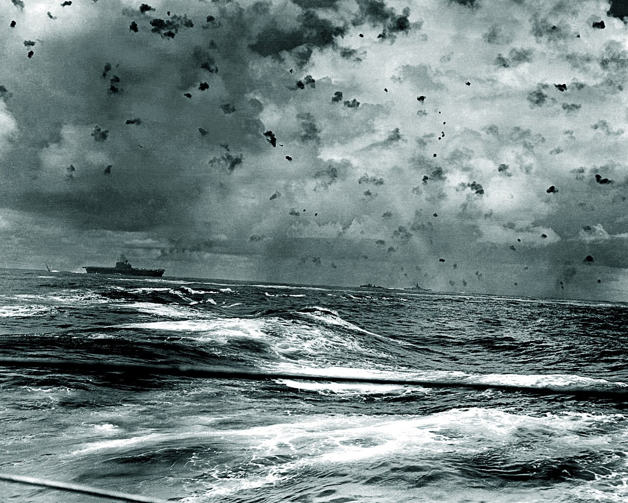 Anti-aircraft shell bursts fill the sky above USS Enterprise and her escorts as Japanese dive bombers attack during the Battle of the Santa Cruz Islands