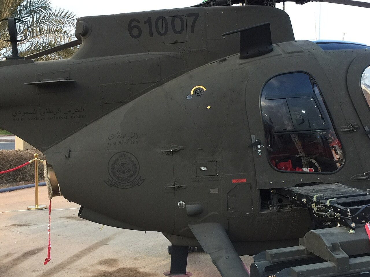 Side view of a Saudi Arabian National Guard AH-6 light attack helicopter showing the National Guard emblem and Arabic lettering