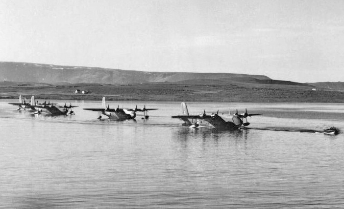 A Short S.23 Empire flying boat taxiing ahead of three Short Sunderlands of No. 204 Squadron RAF at Sullom Voe around 1941