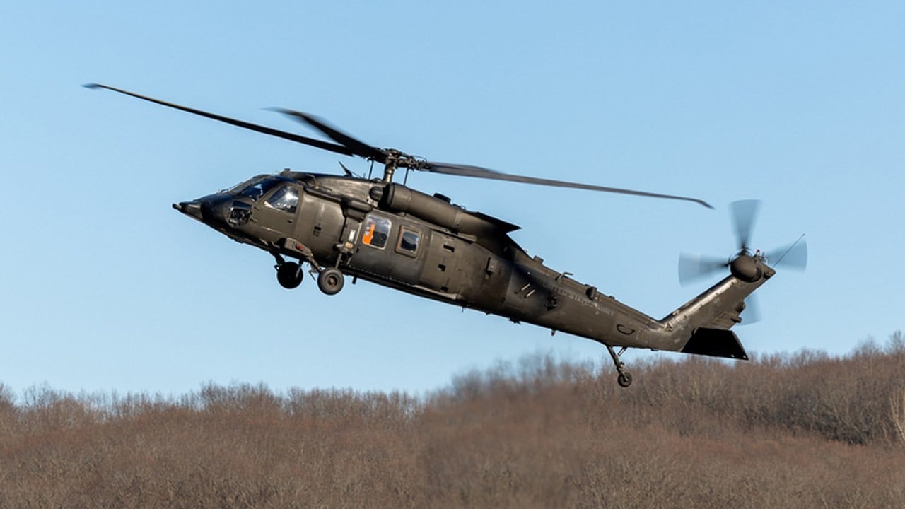 US Army UH-60MX optionally piloted Black Hawk in flight over winter trees