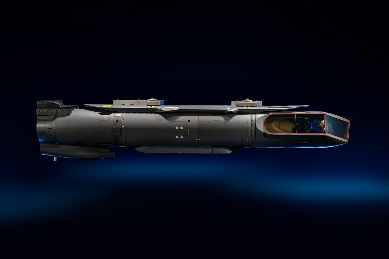 Side view of a Lockheed Martin Sniper ATP-SE targeting pod against a dark background, with its faceted nose section on the right
