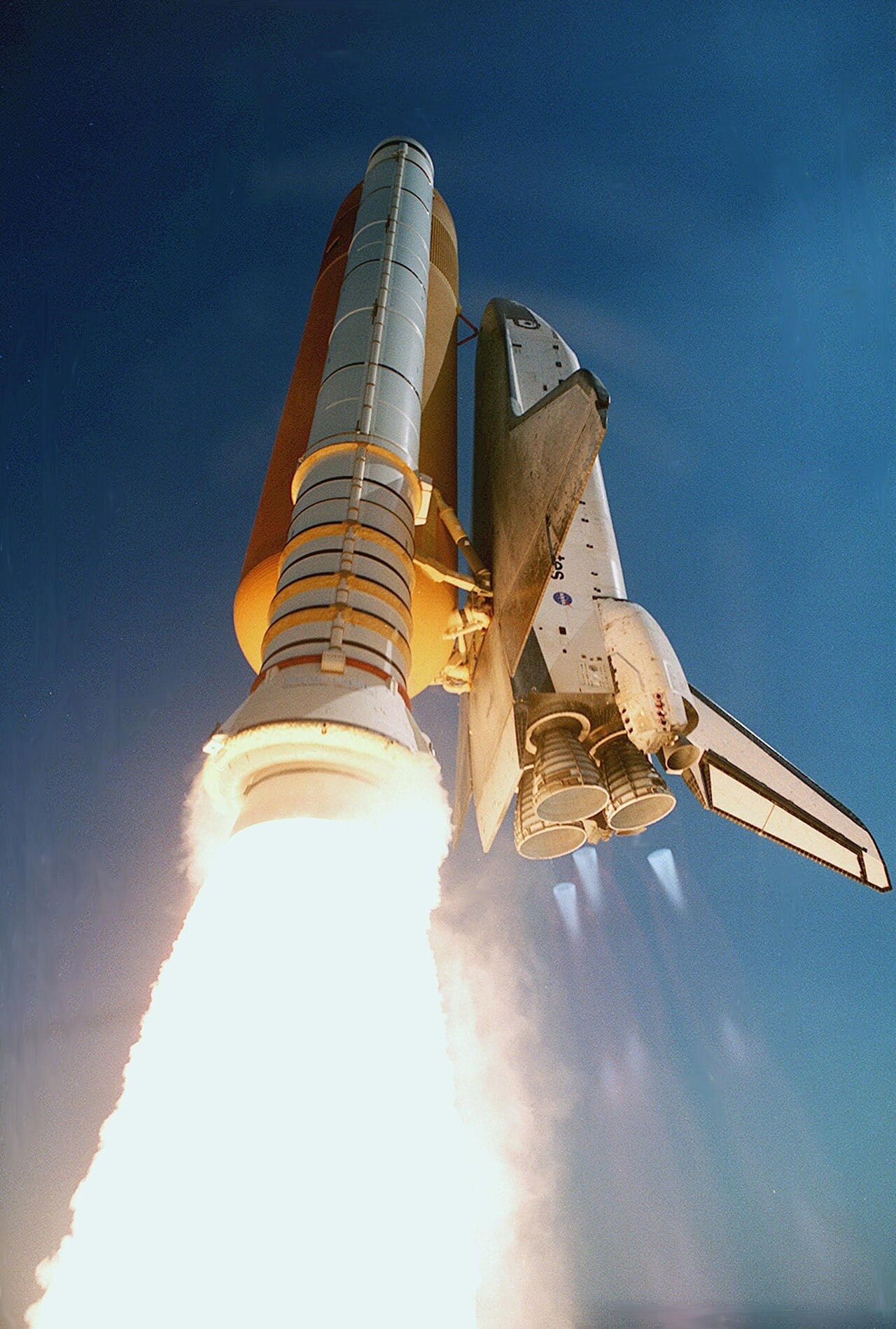 Space Shuttle Endeavour lifting off on STS-99, with faint blue Mach diamonds below its three main engine nozzles beside the bright booster exhaust