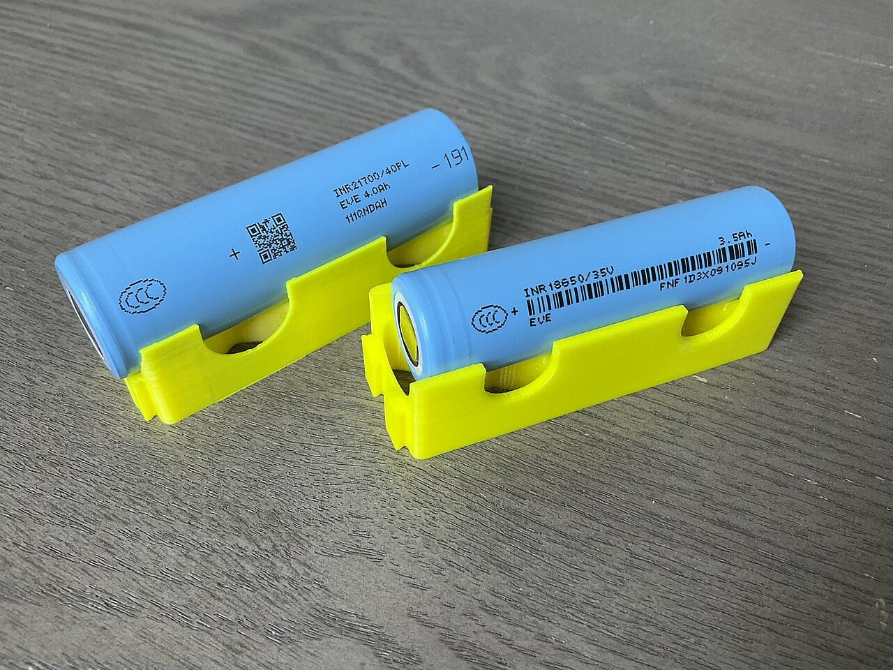 Two cylindrical lithium-ion cells, an 18650 and a 21700, with their capacity markings visible