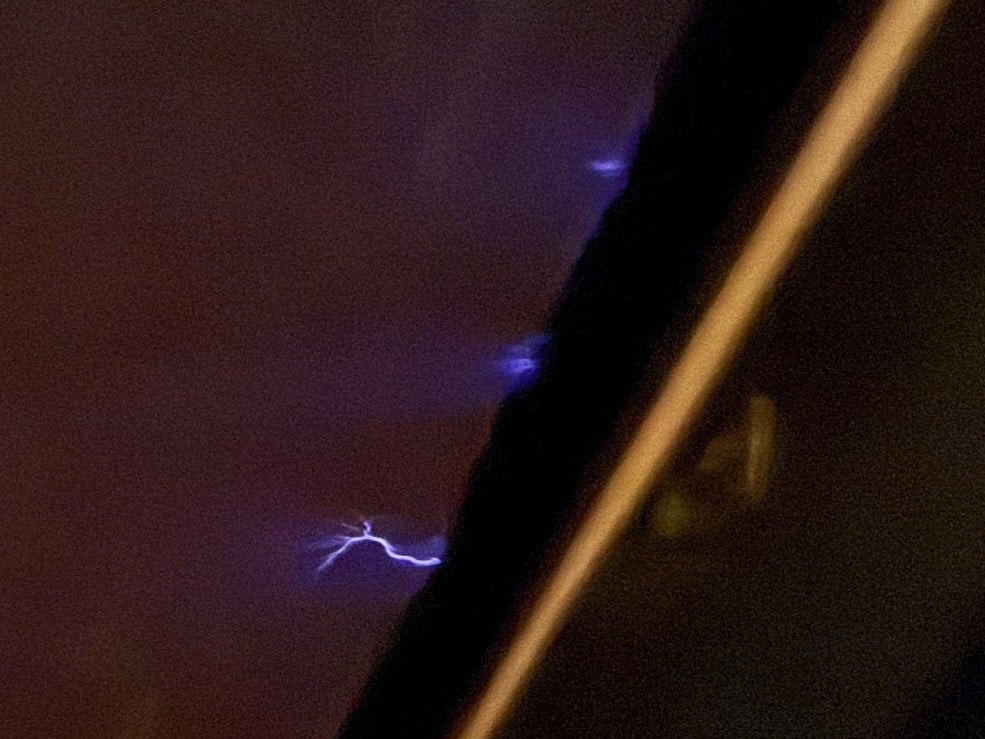 Small violet jets of St Elmo&rsquo;s fire flickering along the edge of an Airbus A320 cockpit windshield at night